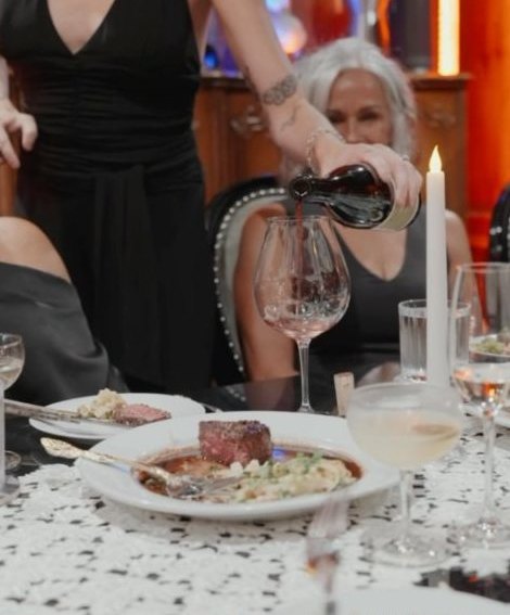 Wine poured tableside at a candlelit dinner